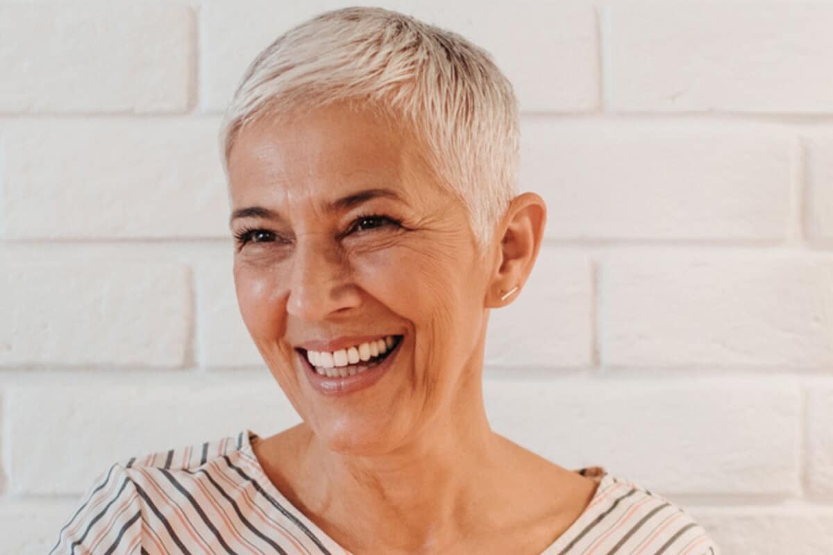 Femme aux cheveux gris courts avec un large sourire








