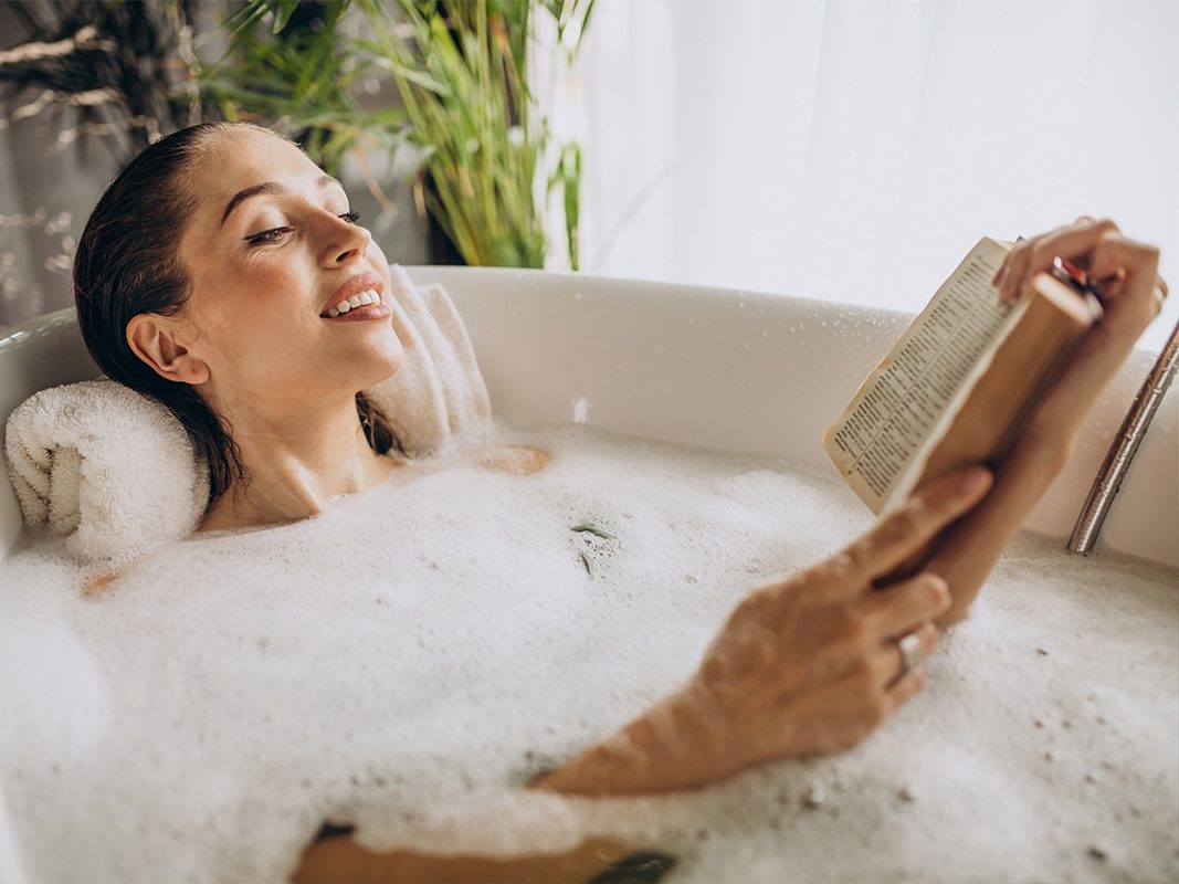 Une femme détendue prenant un bain moussant